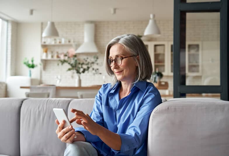 Woman holding phone on couch